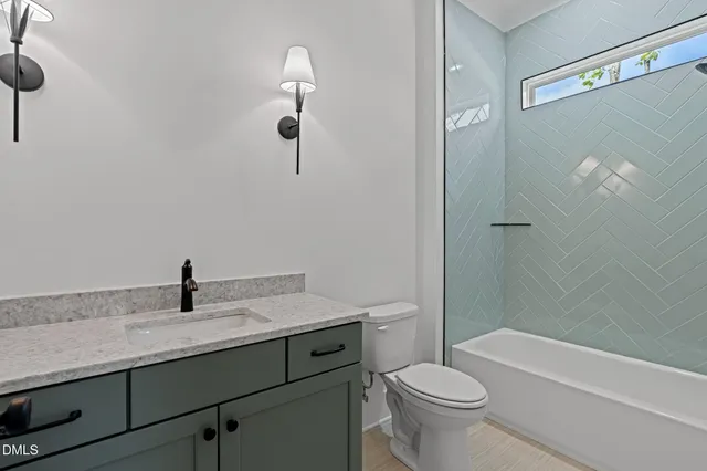 a bathroom with a granite countertop sink a toilet and shower
