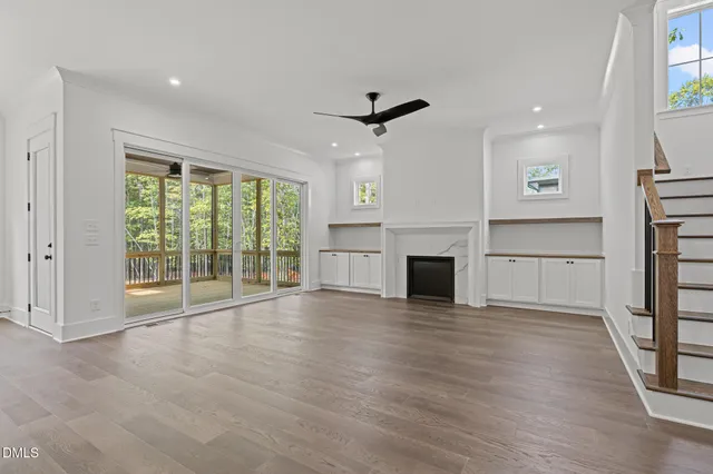 a view of empty room with wooden floor and fireplace