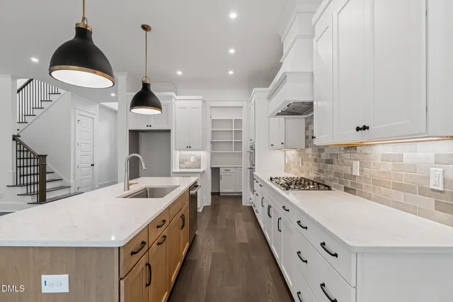 a kitchen with stainless steel appliances a sink a stove and a wooden floors