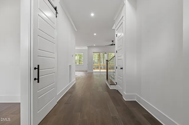 a view of a hallway with wooden floor and staircase