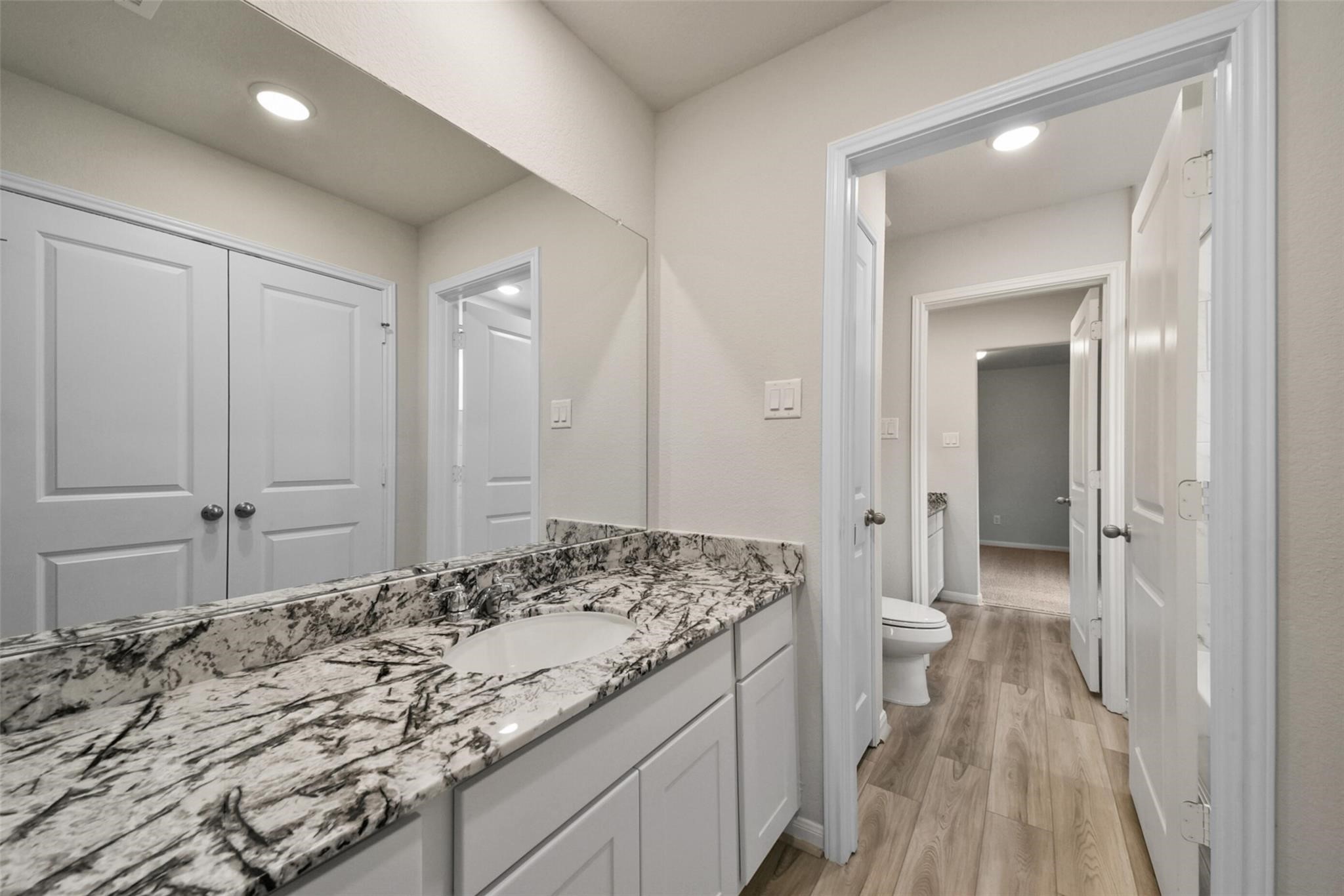 10522 Plumas Run Drive Rosharon, TX 77583 - Photo 22 of 29 Sleek, elegant bathroom featuring a striking marble-patterned vanity, modern lighting, and ample storage.