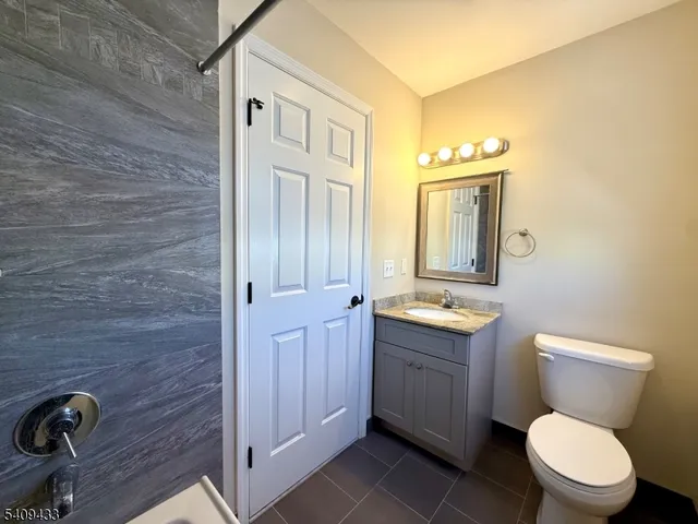 a bathroom with a toilet a sink and mirror