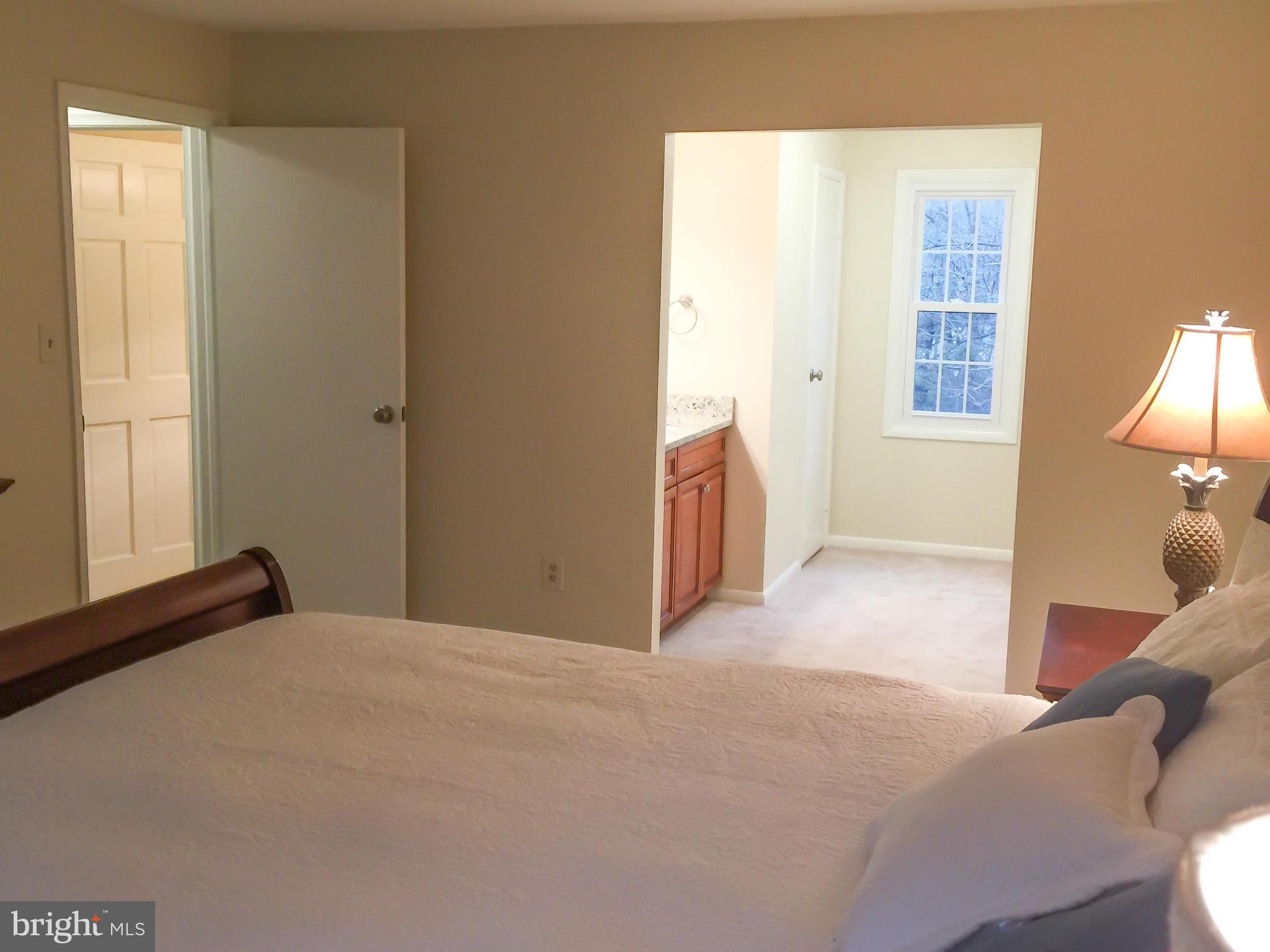 11423 Running Cedar Road Reston, VA 20191 - Photo 17 of 28 a bedroom with a bed and a lamp