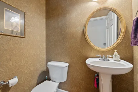 a bathroom with a toilet sink and mirror