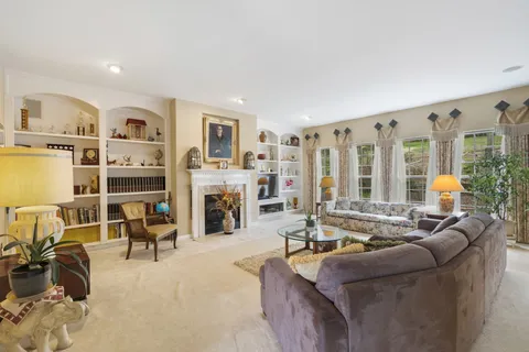 a living room with furniture kitchen view and large windows