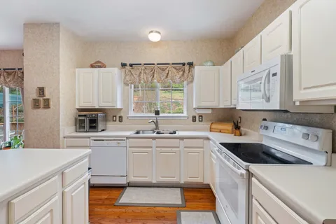 a kitchen with a sink a stove a refrigerator and cabinets