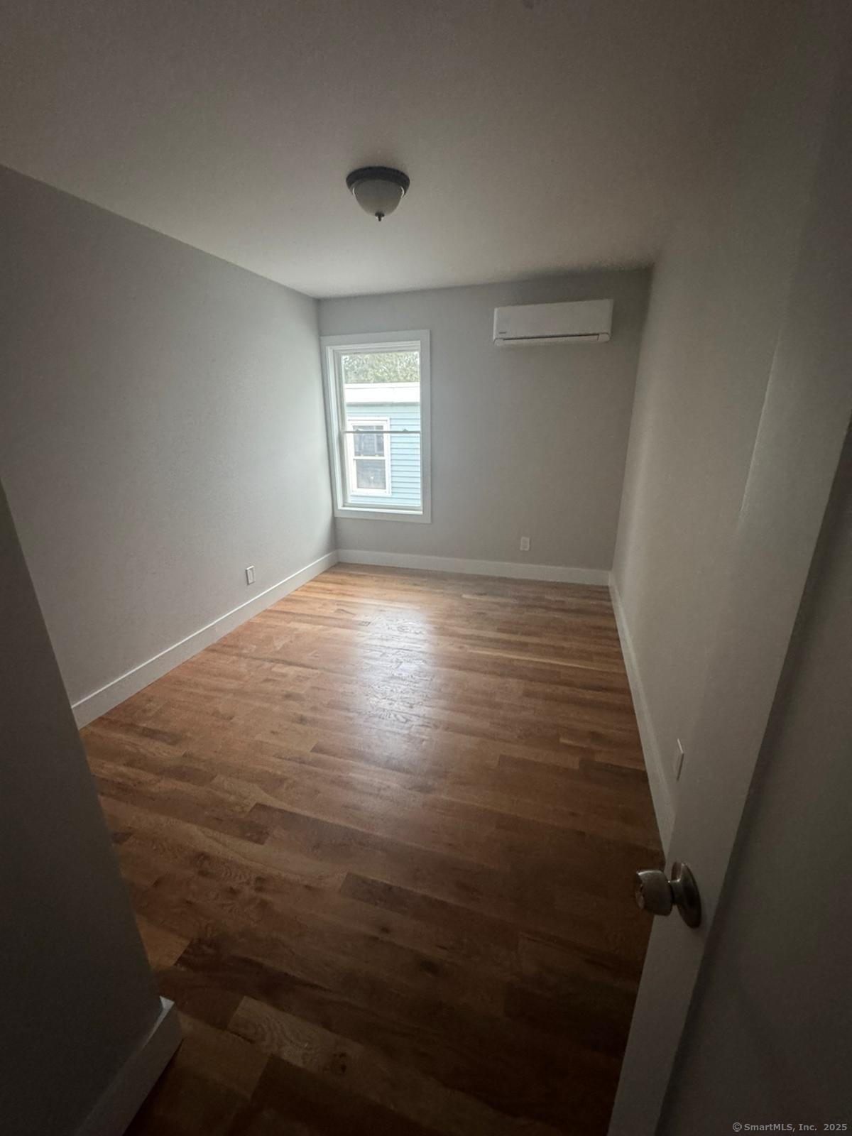 980 Hancock Avenue, Unit 2R Bridgeport, CT 06605 - Photo 3 of 7 wooden floor in an empty room with a window