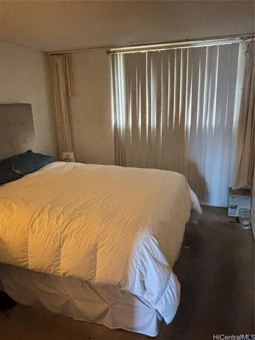 a large bed sitting in a bedroom next to a window
