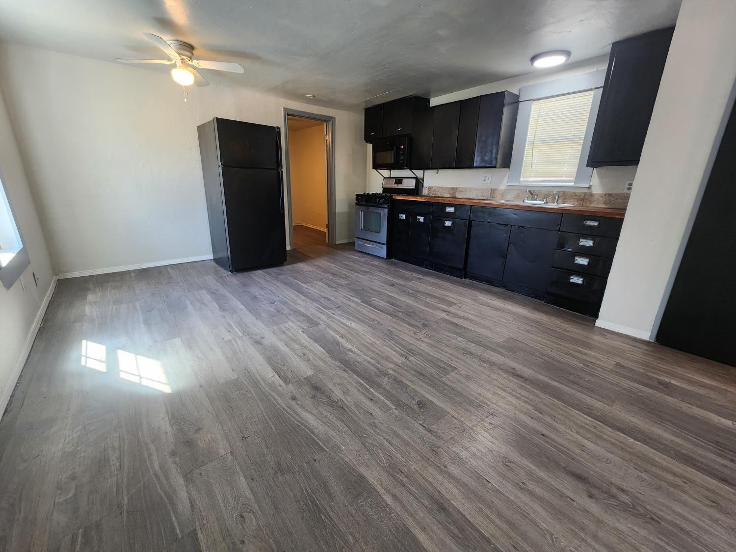 2103 38th Street, Unit B Lubbock, TX 79412 - Photo 2 of 6 a view of kitchen with wooden floor and electronic appliances