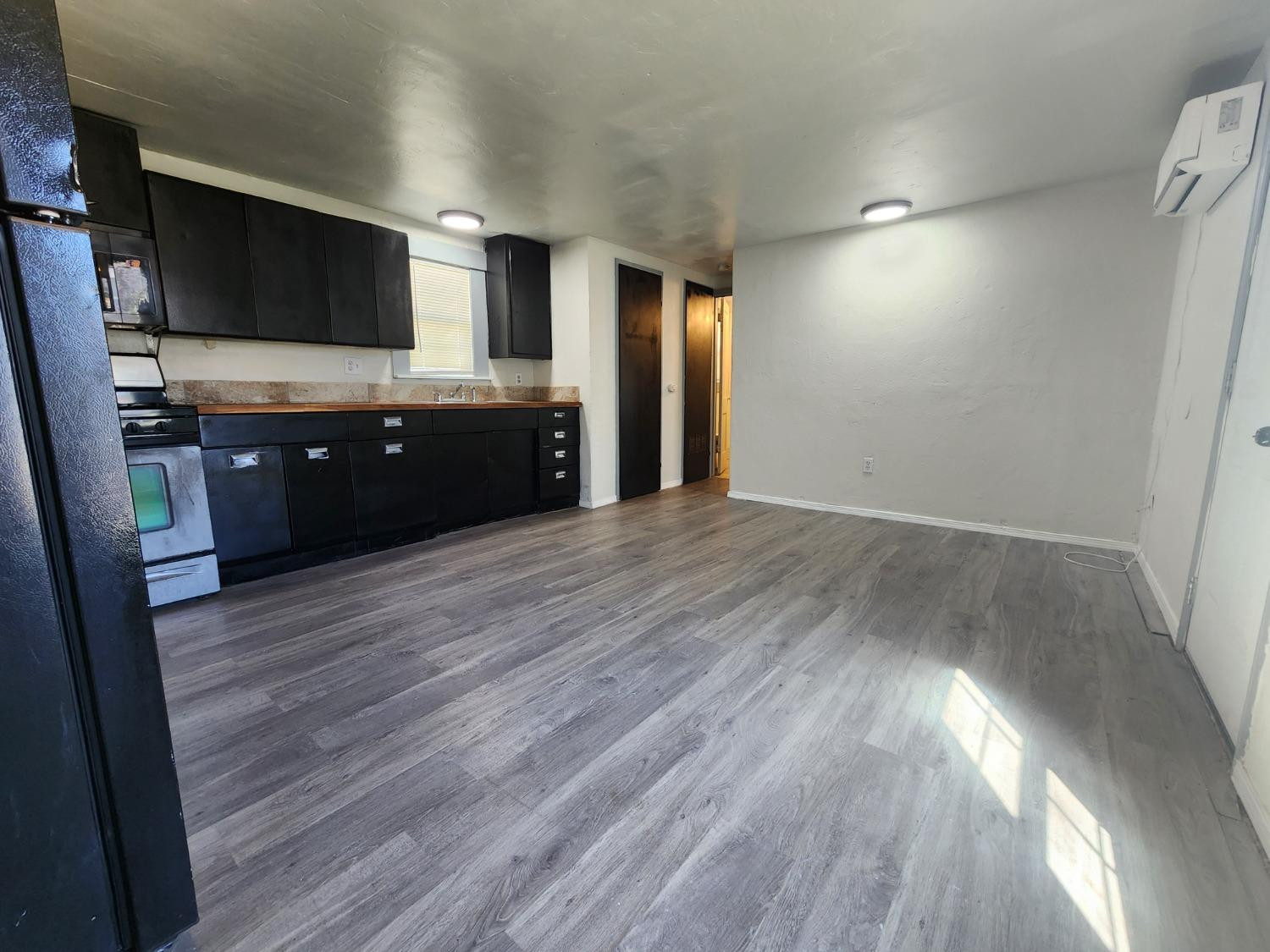 2103 38th Street, Unit B Lubbock, TX 79412 - Photo 3 of 6 a living room with hard wood floors and a fireplace