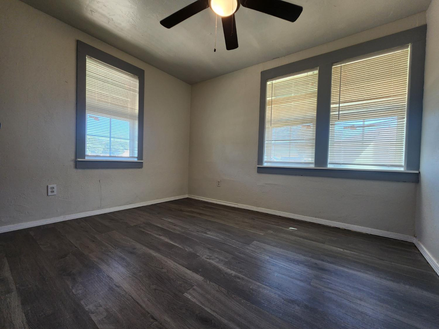 2103 38th Street, Unit B Lubbock, TX 79412 - Photo 4 of 6 a view of an empty room with wooden floor and a window