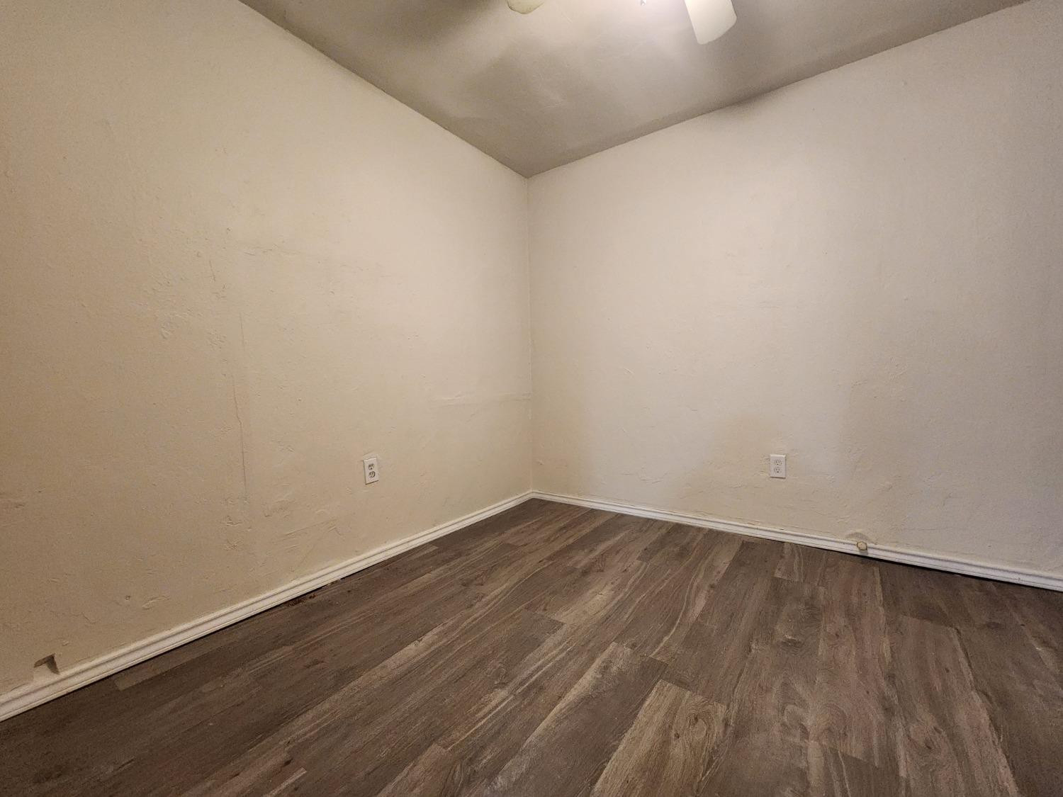 2103 38th Street, Unit B Lubbock, TX 79412 - Photo 6 of 6 a view of an empty room with wooden floor
