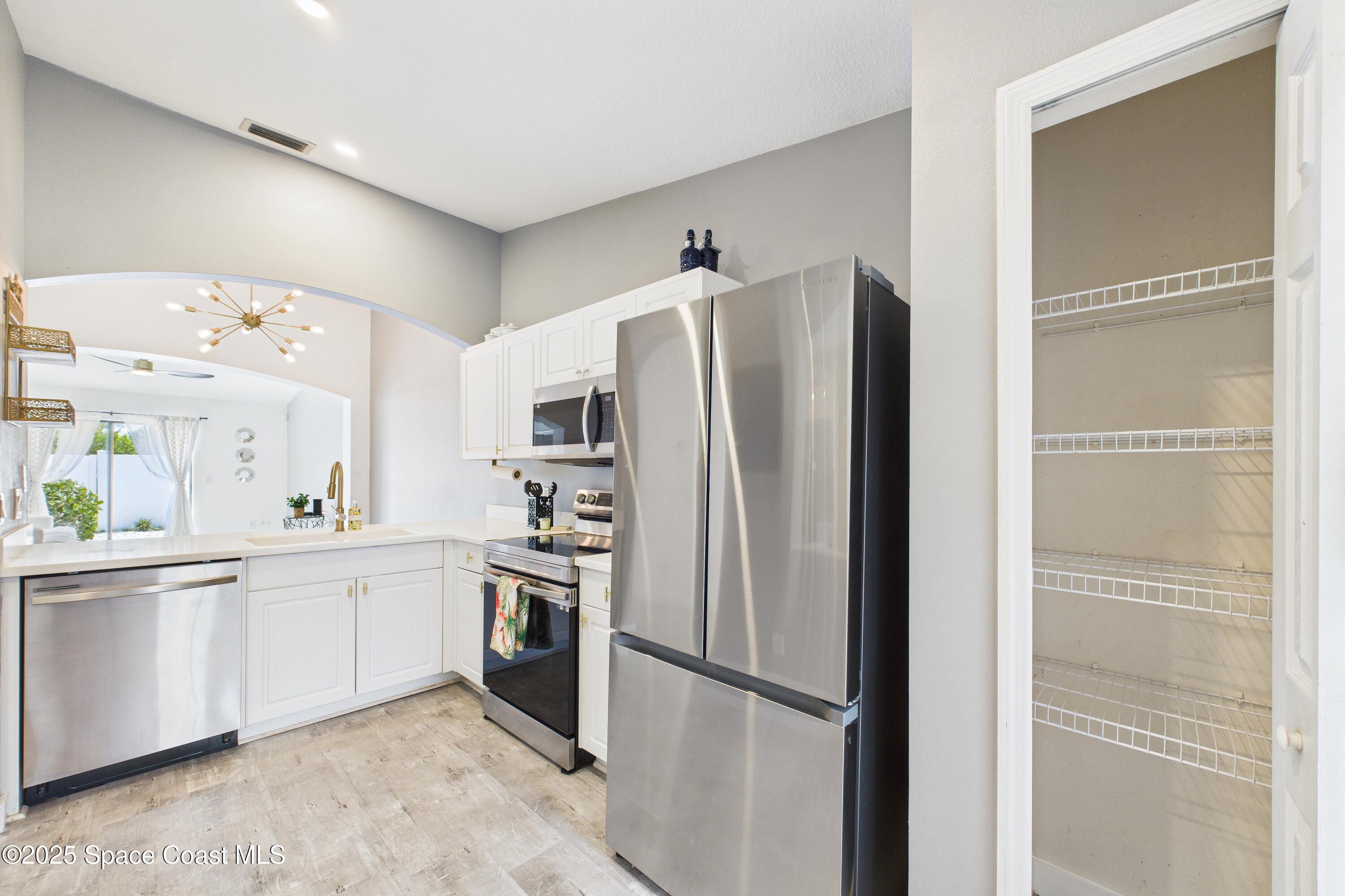 1010 Luminary Circle, Unit 104 Melbourne, FL 32901 - Photo 13 of 42 a kitchen with stainless steel appliances a refrigerator and a sink