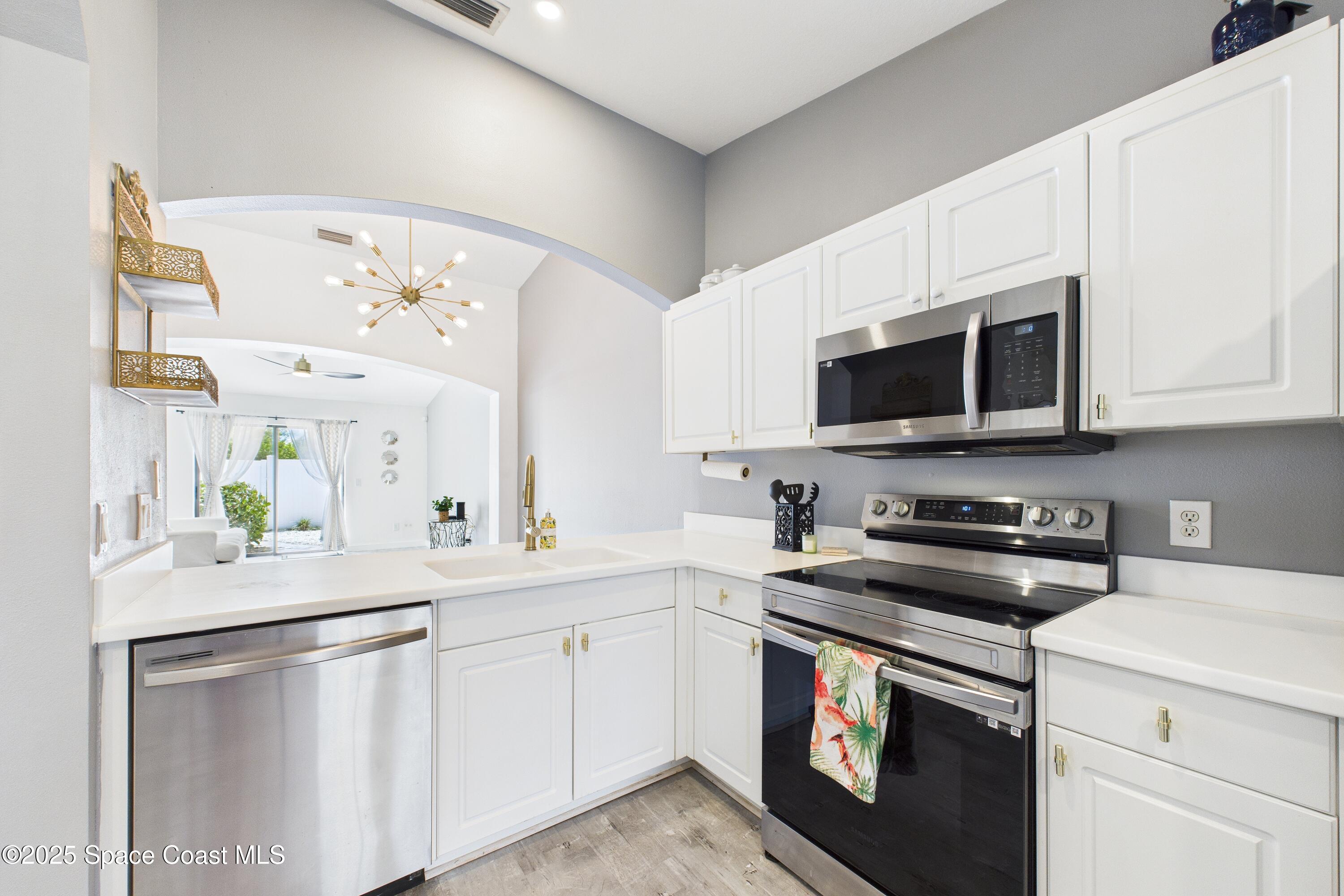 1010 Luminary Circle, Unit 104 Melbourne, FL 32901 - Photo 14 of 42 a kitchen with stainless steel appliances granite countertop a sink and a microwave