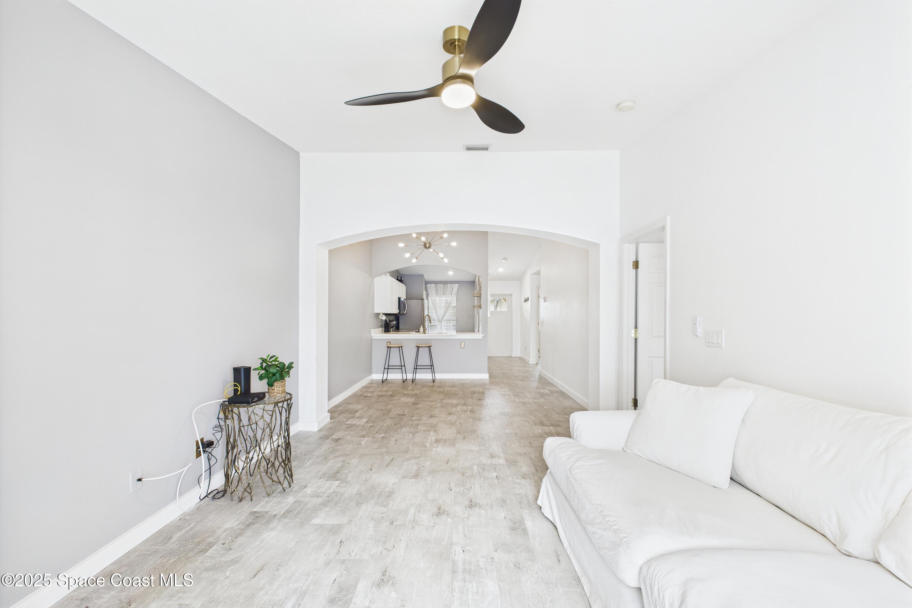 1010 Luminary Circle, Unit 104 Melbourne, FL 32901 - Photo 22 of 42 a living room with furniture and a chandelier