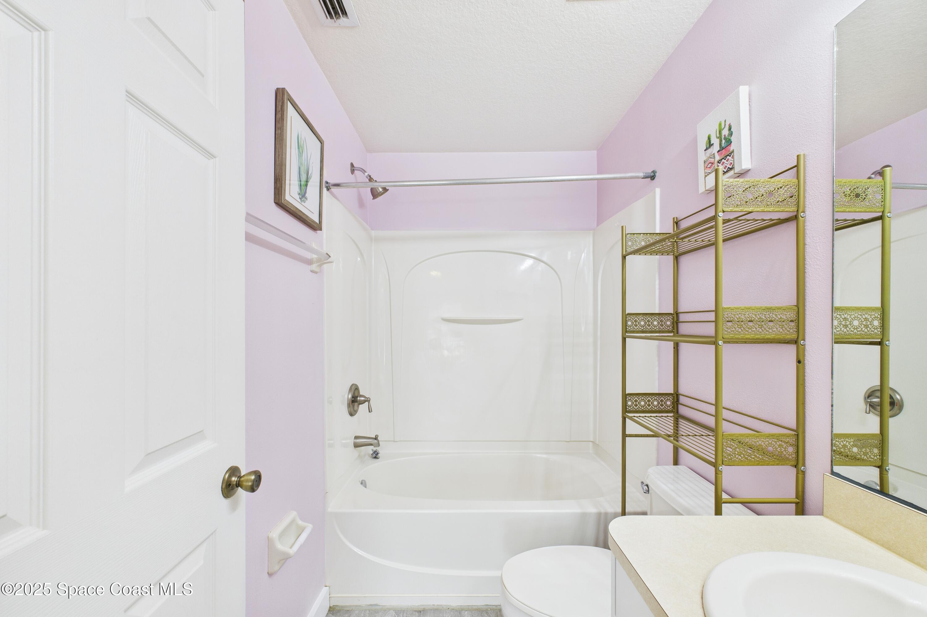 1010 Luminary Circle, Unit 104 Melbourne, FL 32901 - Photo 29 of 42 a bathroom with a granite countertop bathtub shower sink vanity and toilet