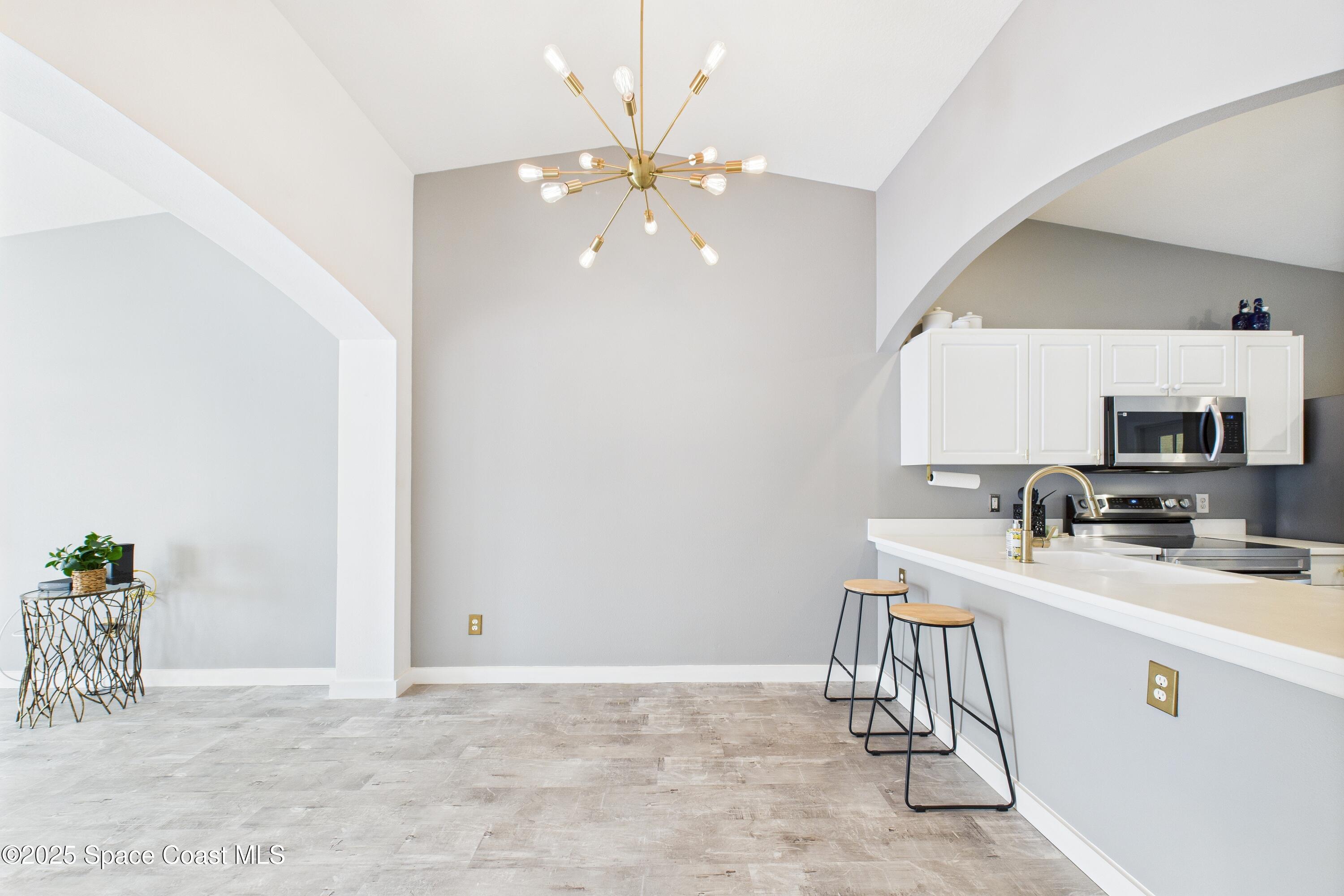 1010 Luminary Circle, Unit 104 Melbourne, FL 32901 - Photo 3 of 42 a room with a sink chandelier and a dining table