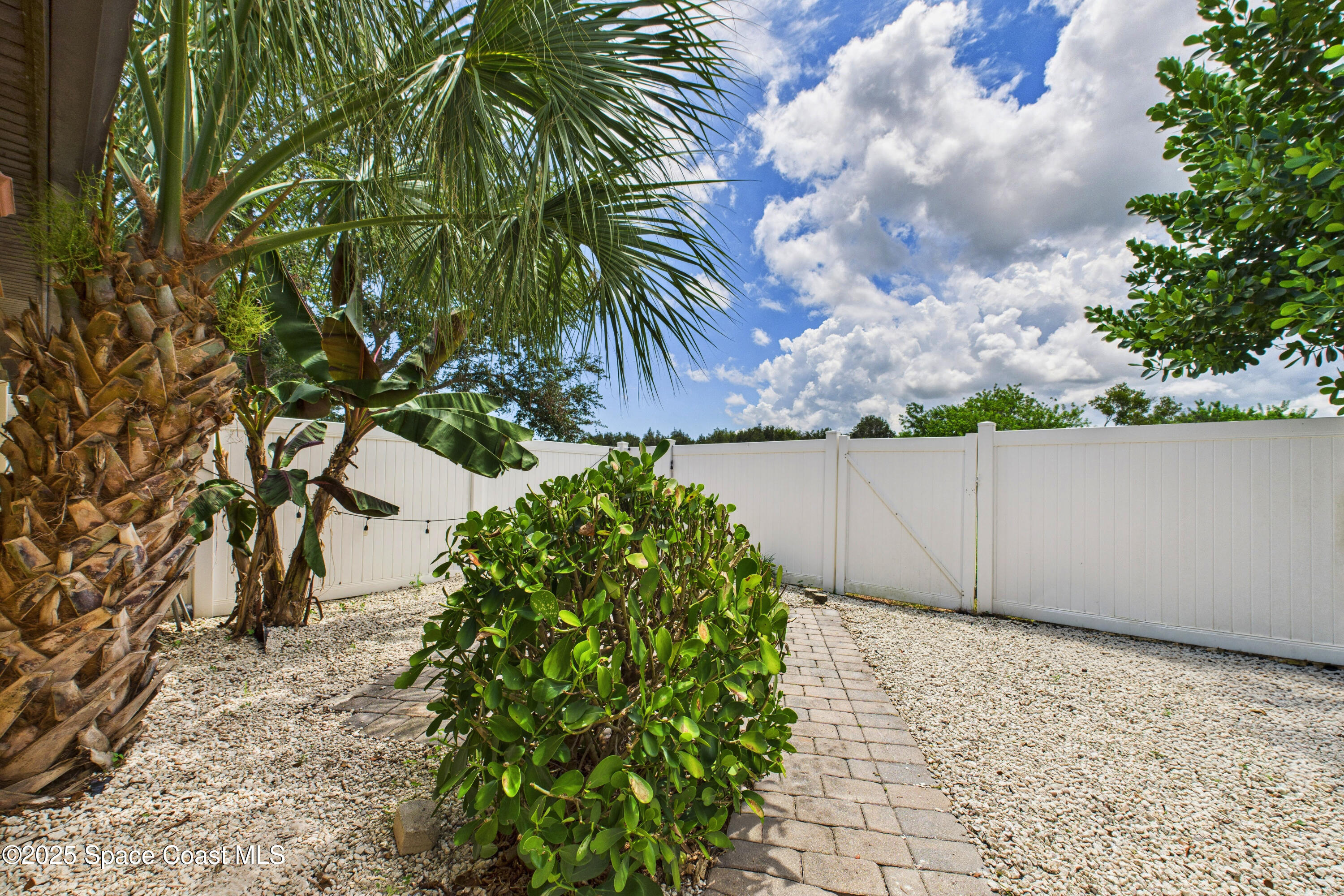 1010 Luminary Circle, Unit 104 Melbourne, FL 32901 - Photo 40 of 42 a view of a yard with plants and wooden fence