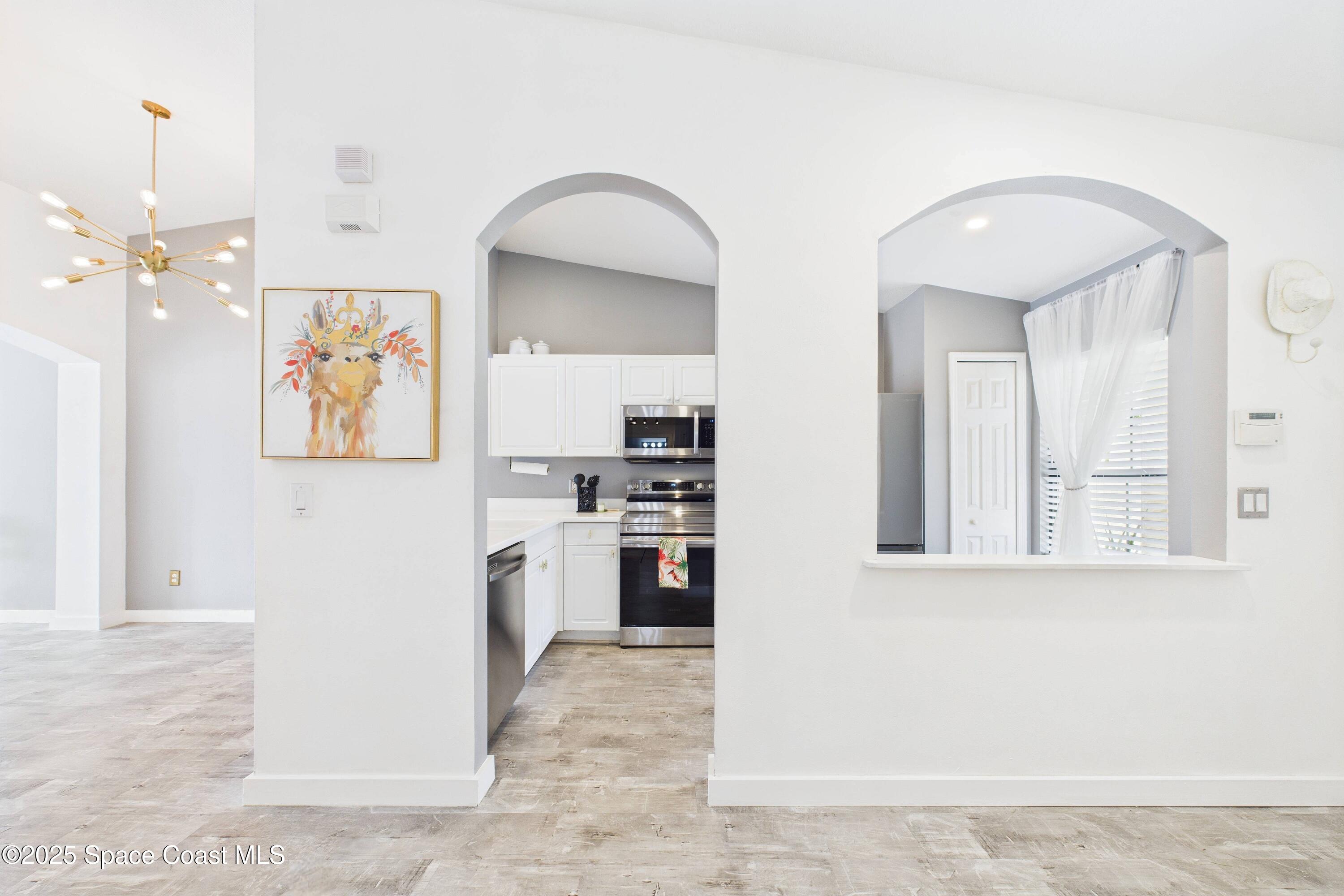 1010 Luminary Circle, Unit 104 Melbourne, FL 32901 - Photo 4 of 42 wooden floor with kitchen view and stainless steel appliances
