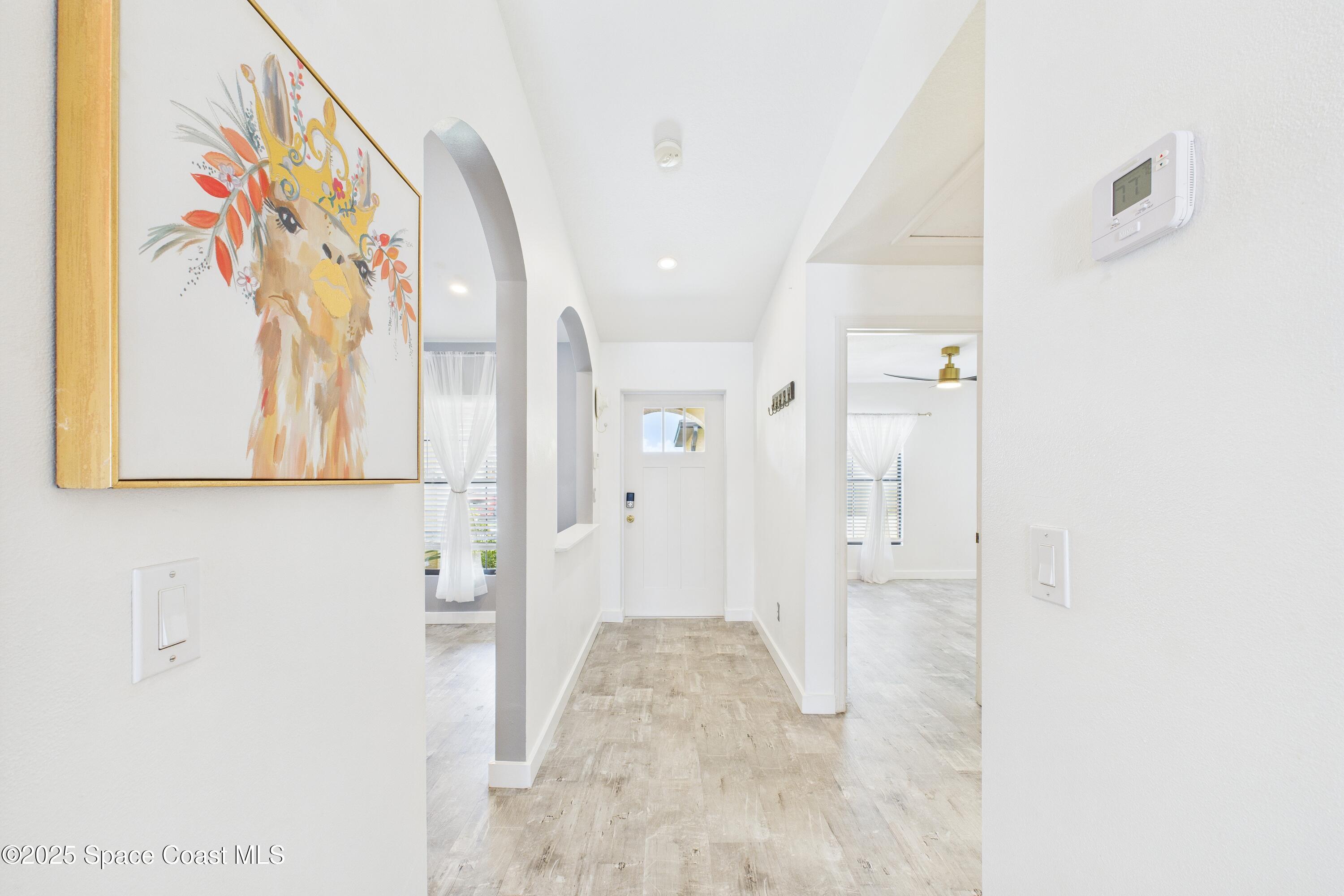 1010 Luminary Circle, Unit 104 Melbourne, FL 32901 - Photo 5 of 42 a view of a hallway with paintings on the wall