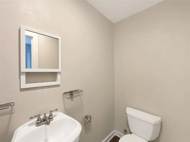 a bathroom with a sink mirror and toilet