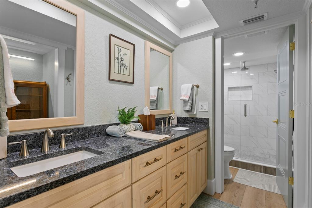 16332 Gulf Boulevard, Unit 3B Redington Beach, FL 33708 - Photo 16 of 91 a bathroom with a granite countertop double vanity sink a mirror and a shower