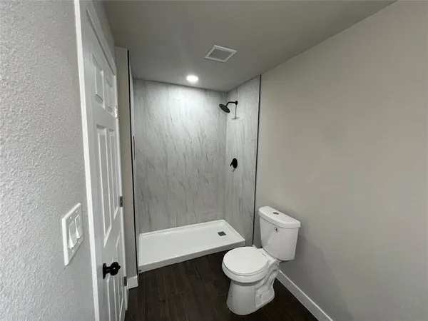 a bathroom with a shower toilet and sink
