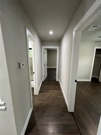 a view of a hallway with wooden floor