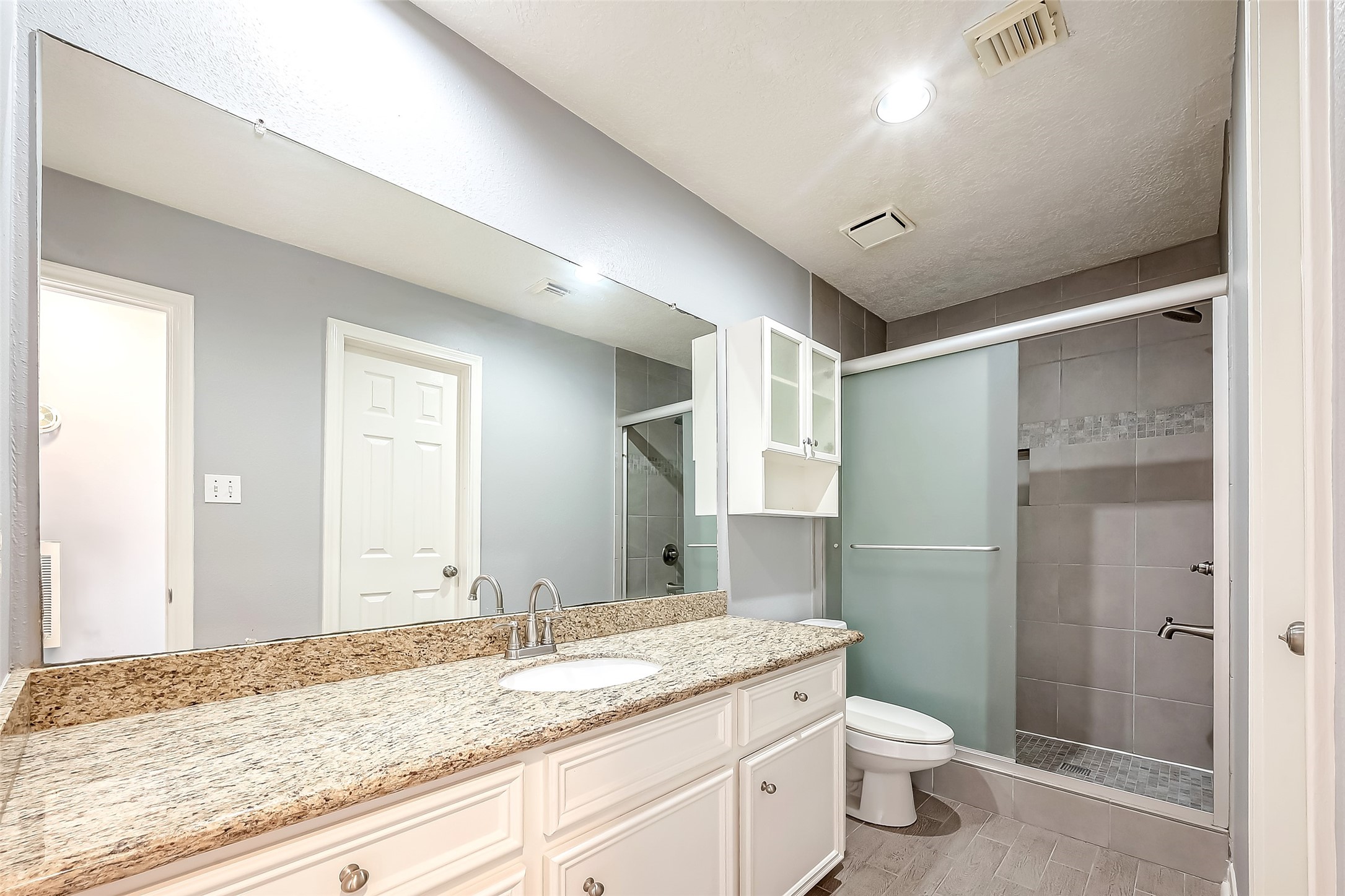 16018 Conners Ace Drive Spring, TX 77379 - Photo 40 of 47 a bathroom with a granite countertop sink a toilet and shower