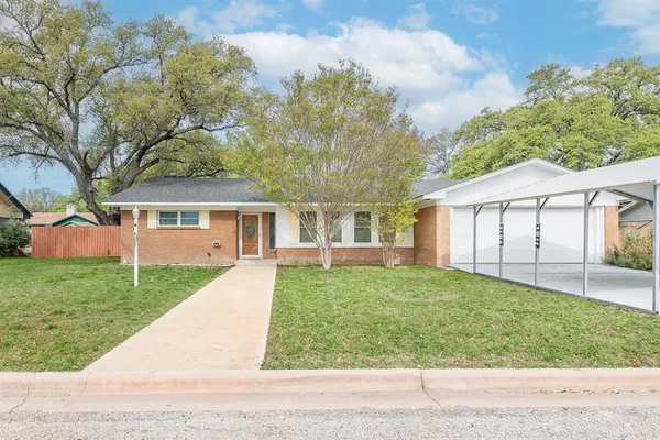a view of a house with backyard and a tree