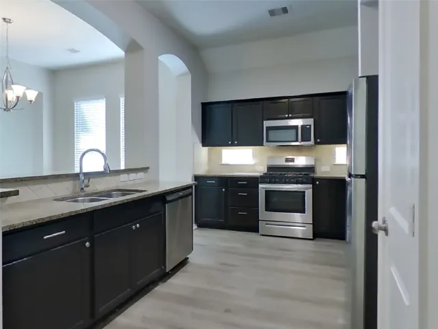 a kitchen with stainless steel appliances granite countertop a stove and a sink