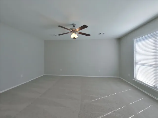 an empty room with a window and a fan