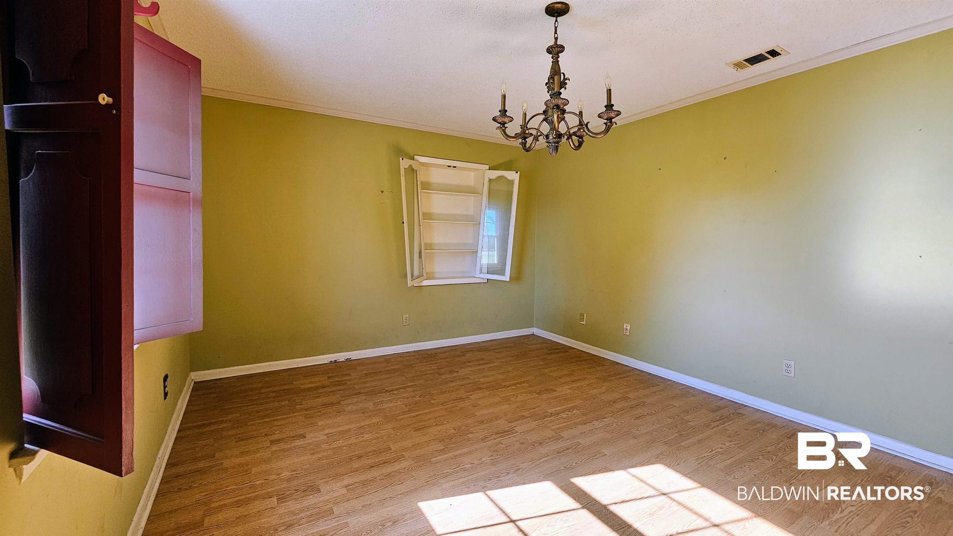 18824 Highway 41 Brewton, AL 36426 - Photo 27 of 40 Spacious room featuring wood-finish flooring, a decorative chandelier, and a built-in wall cabinet with open shelving