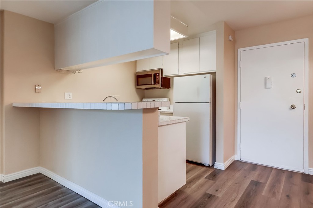 5585 Pacific Coast Highway, Unit 140 Long Beach, CA 90804 - Photo 14 of 47 a kitchen with a refrigerator and a microwave