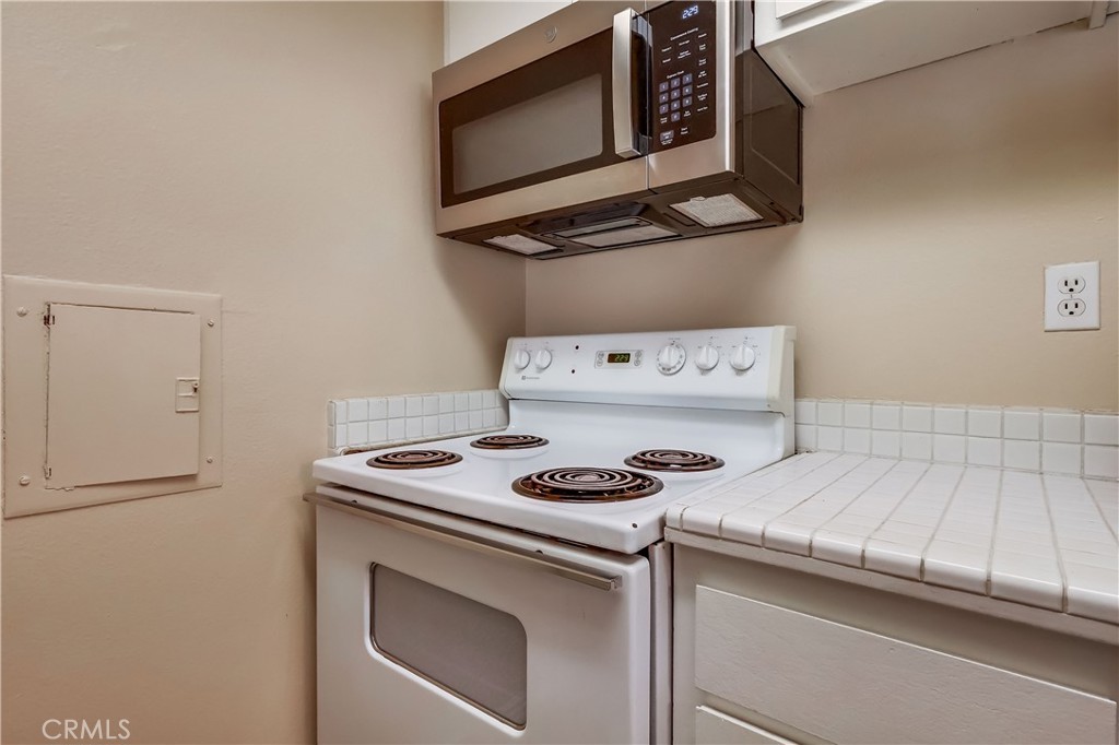 5585 Pacific Coast Highway, Unit 140 Long Beach, CA 90804 - Photo 19 of 47 a kitchen with a stove and a microwave