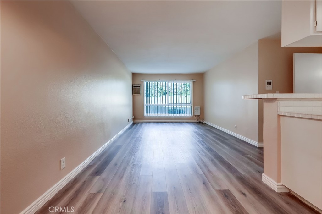 5585 Pacific Coast Highway, Unit 140 Long Beach, CA 90804 - Photo 5 of 47 wooden floor in an empty room with a window