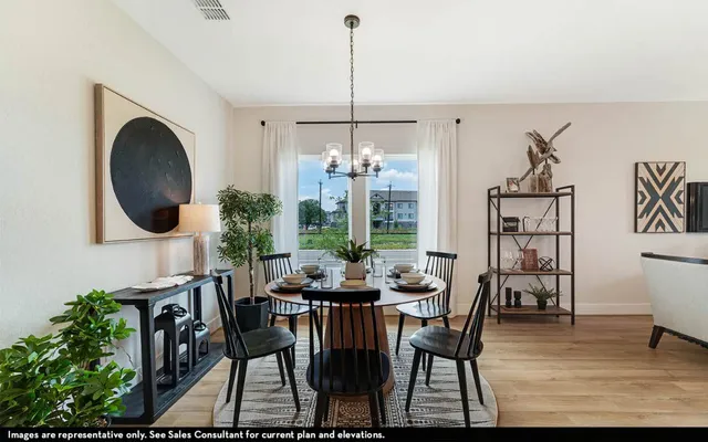 a dining room with furniture a chandelier and wooden floor