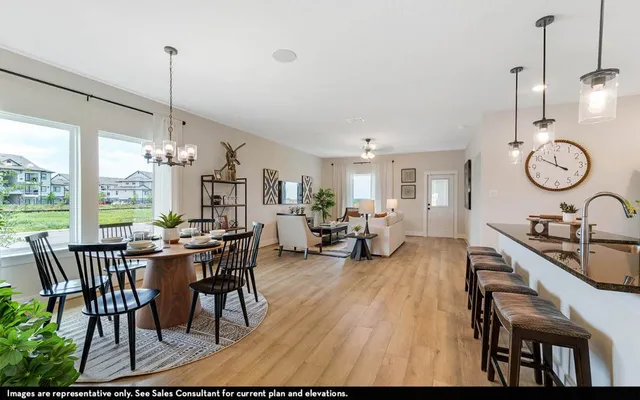 a view of a dining room and livingroom with furniture wooden floor a chandelier