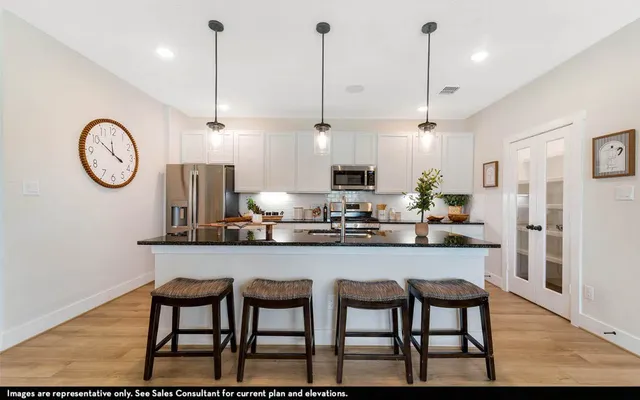 a kitchen with stainless steel appliances granite countertop a kitchen island a stove a table and chairs