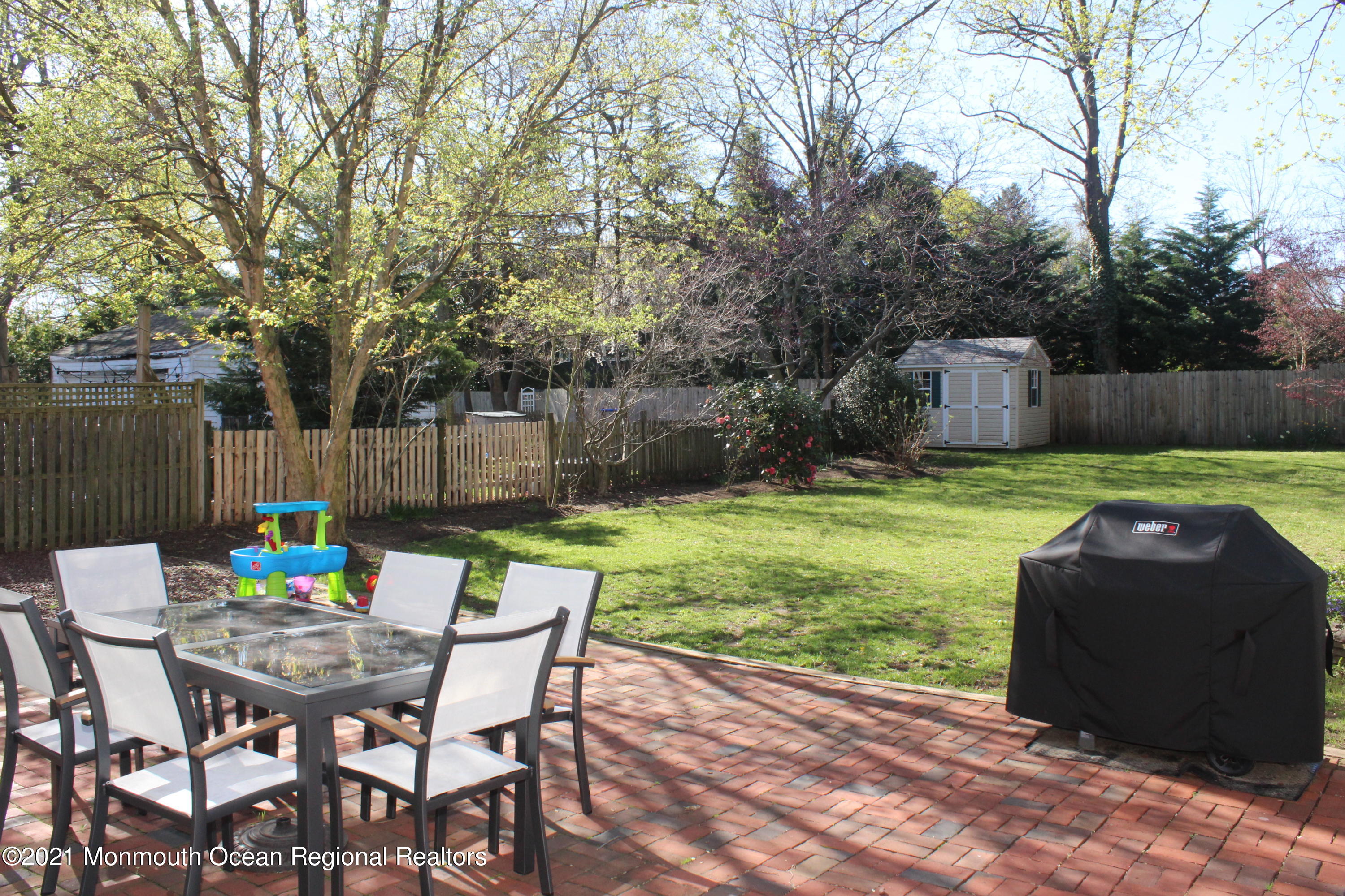 675 River Road Fair Haven, NJ 07704 - Photo 26 of 36 a view of a backyard with table and chairs potted plants and wooden fence