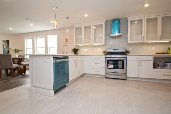 a kitchen with stainless steel appliances granite countertop a stove top oven a sink a refrigerator and white cabinets