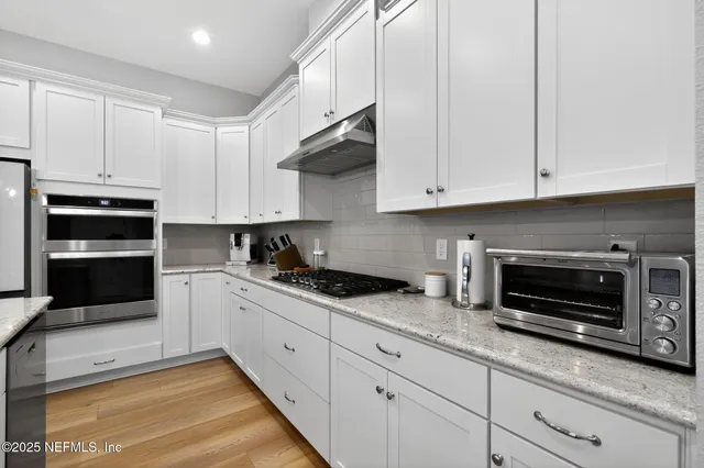 a kitchen with granite countertop a stove a microwave and cabinets
