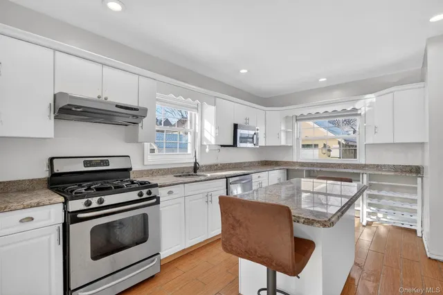 a kitchen with stainless steel appliances a stove a sink and cabinets