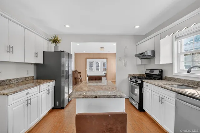 a kitchen with stainless steel appliances granite countertop a stove refrigerator sink and cabinets