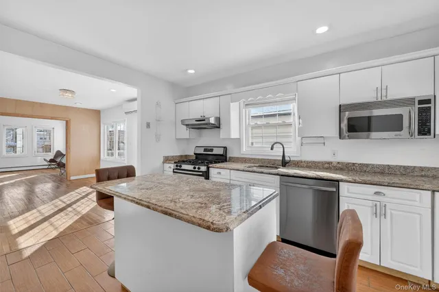 a kitchen with granite countertop stainless steel appliances a sink stove and cabinets