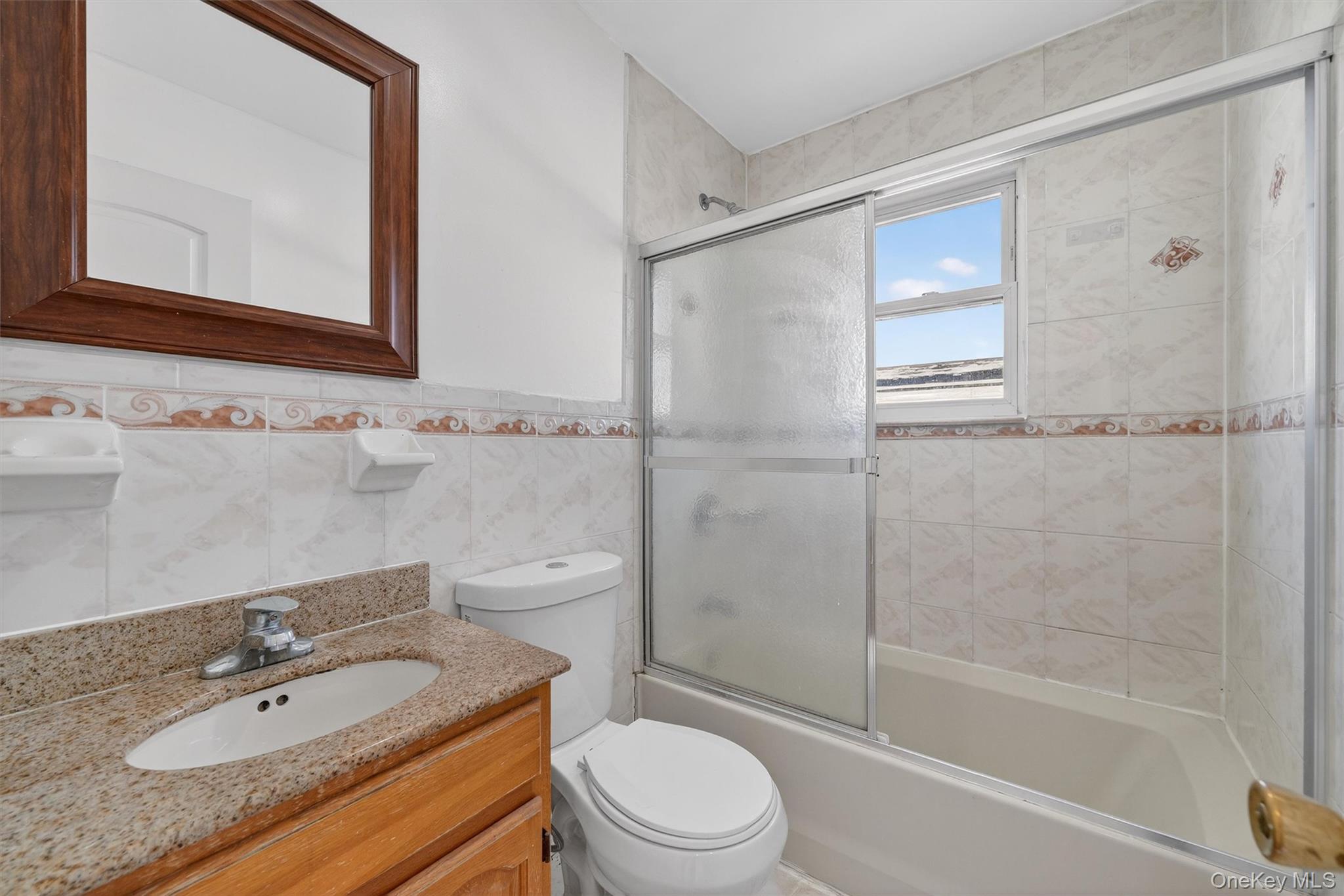 138-16 230th Street Queens, NY 11413 - Photo 26 of 49 Bathroom featuring combined bath / shower with glass door and tile walls