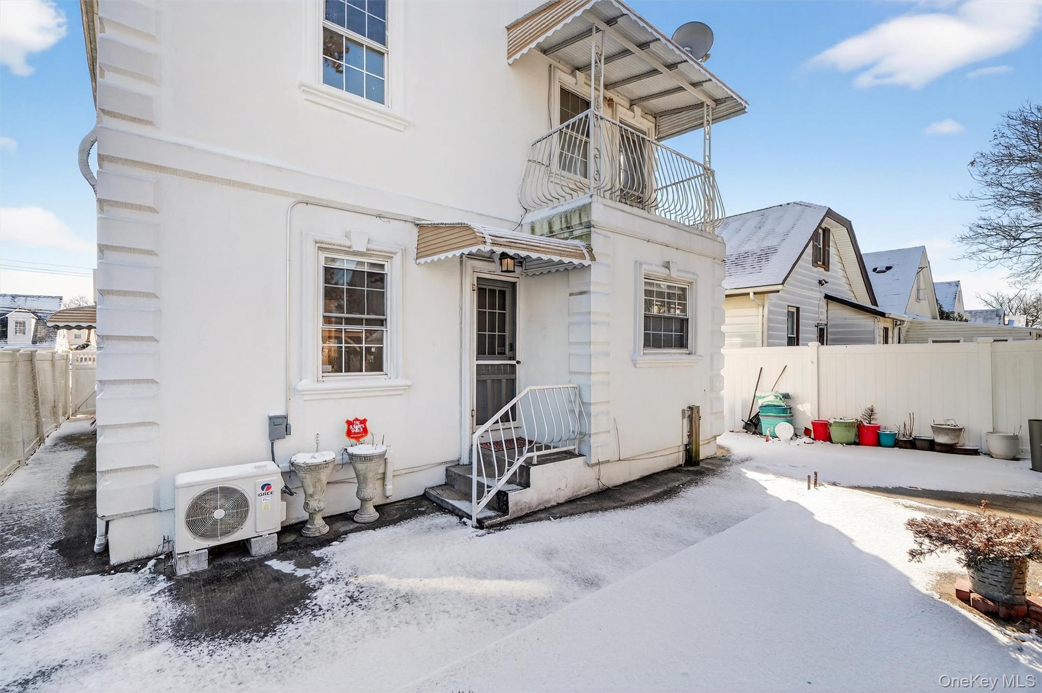 138-16 230th Street Queens, NY 11413 - Photo 46 of 49 Rear view of property featuring a balcony, a fenced backyard, and stucco siding