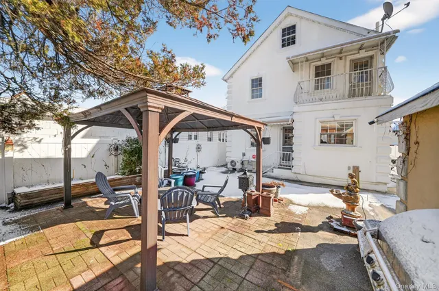 a view of a patio with table and chairs potted plants with wooden floor and fence
