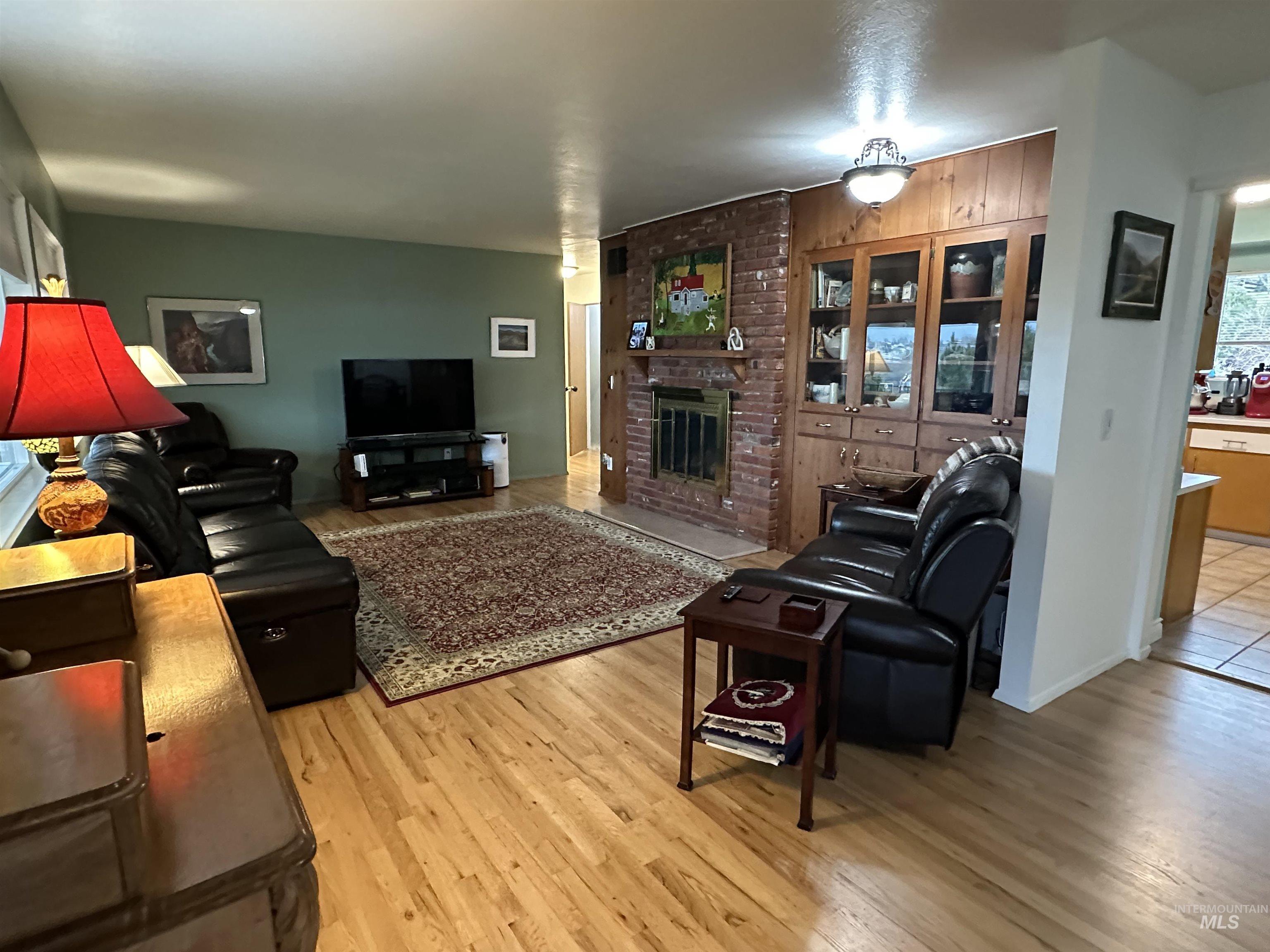 3214 Meadowlark Drive Lewiston, ID 83501 - Photo 8 of 25 Living area featuring a brick fireplace and light wood finished floors