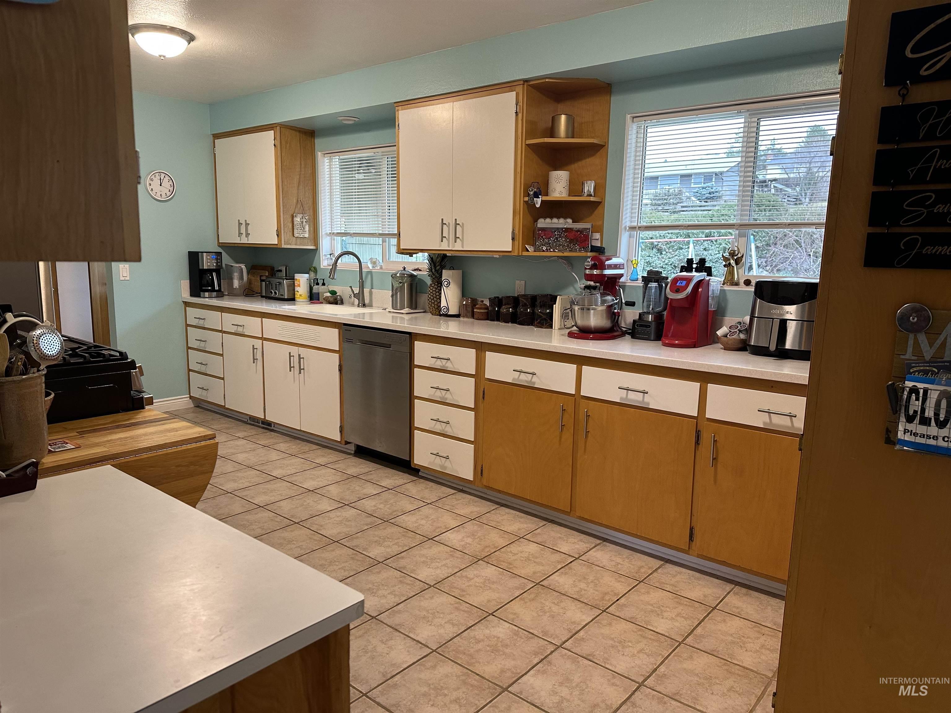 3214 Meadowlark Drive Lewiston, ID 83501 - Photo 10 of 25 Kitchen featuring light countertops, stainless steel dishwasher, open shelves, and light tile patterned flooring